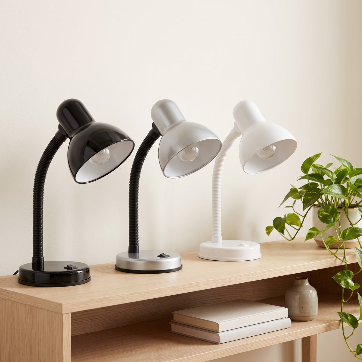 Lloytron 35W Classic Flexi desk lamps in black, silver and white on a wooden shelf