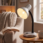 Lloytron 35W Classic Flexi desk lamp, silver, lit beside an armchair and an open book