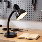 Lloytron 35W Classic Flexi desk lamp, black, lit over a workbench