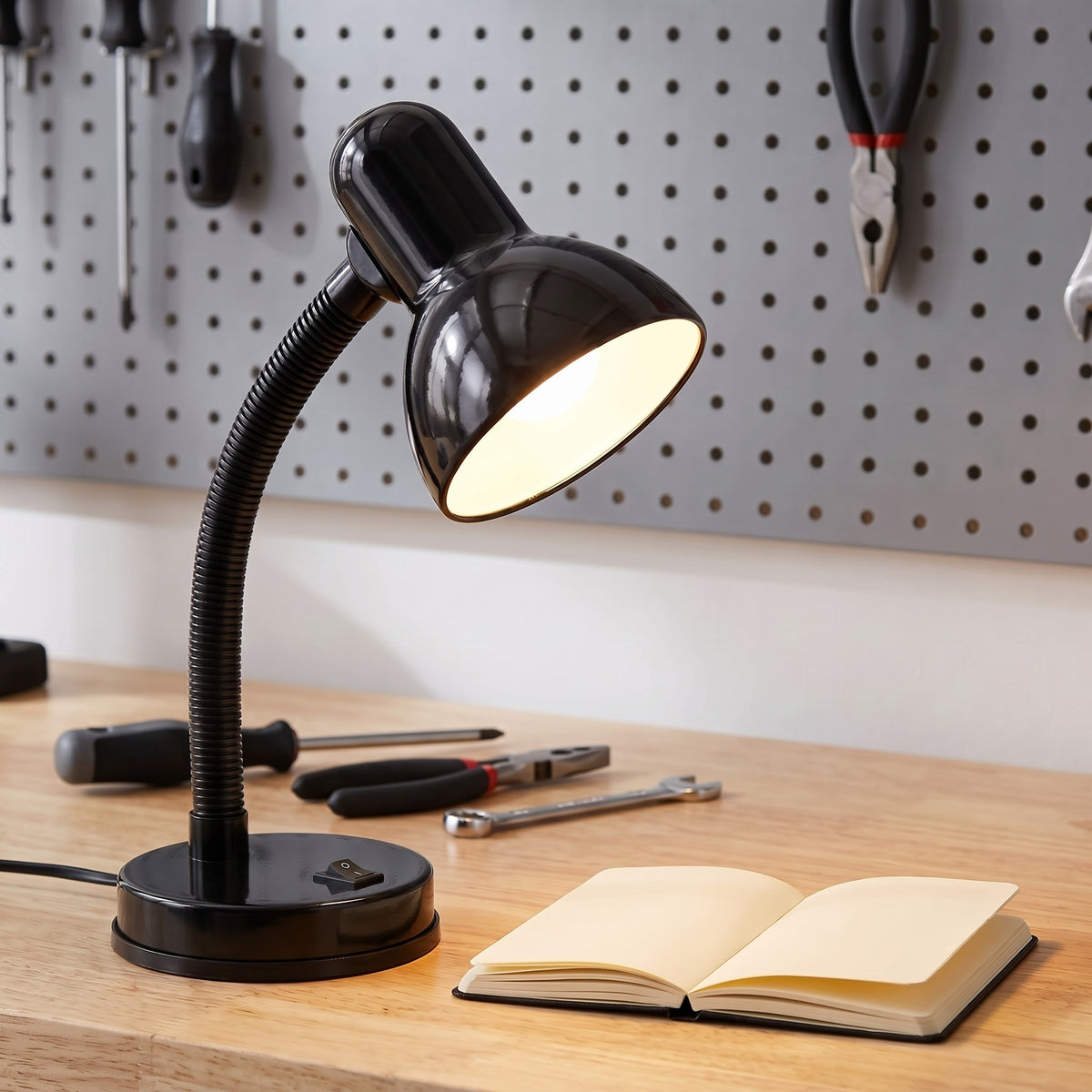 Lloytron 35W Classic Flexi desk lamp, black, lit over a workbench