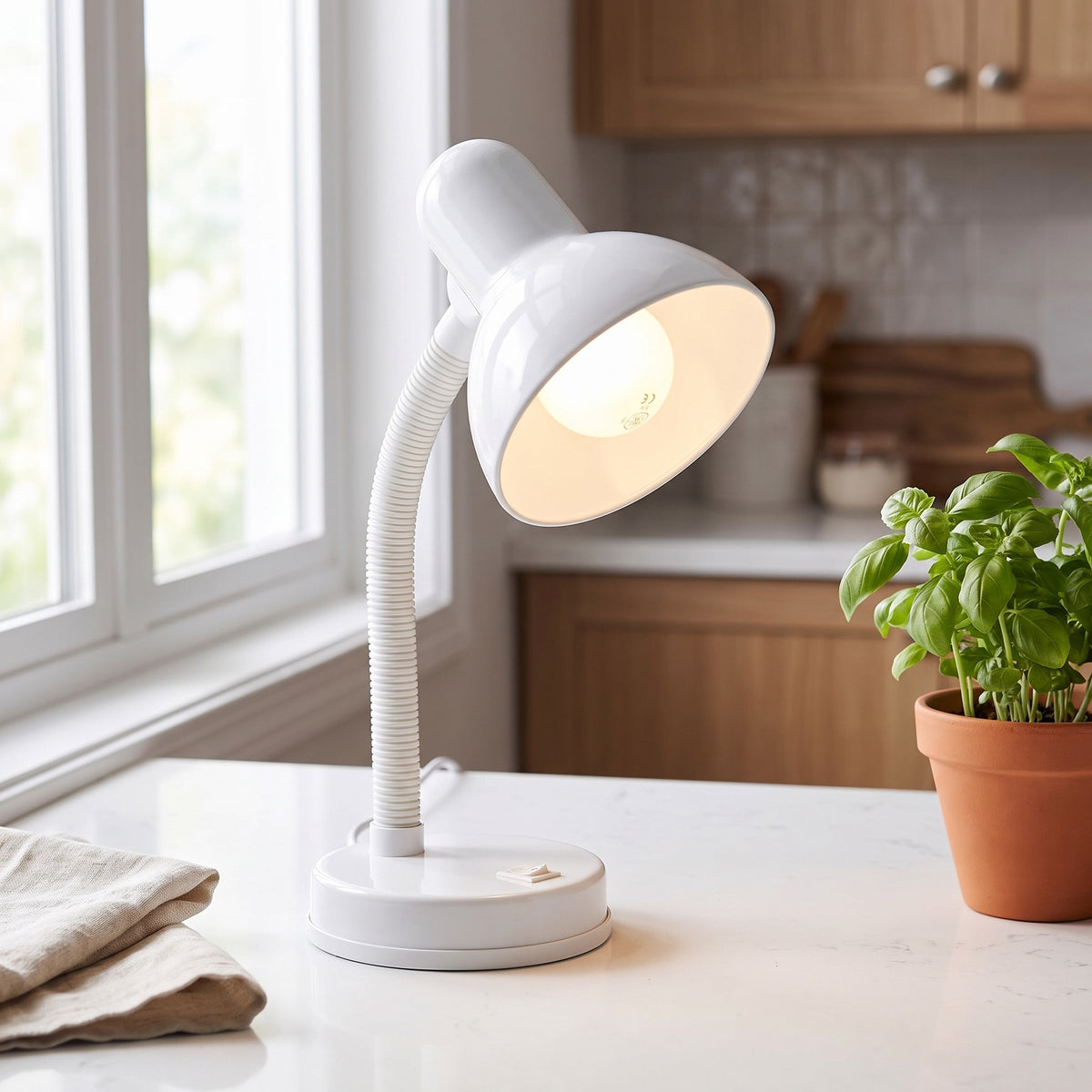 Lloytron 35W Classic Flexi desk lamp, white, lit on a kitchen shelf